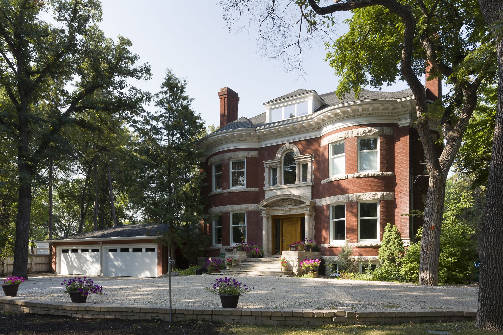 Historic character rich red brick home, with limestone trim, arched windows, grand entry, three-car garage, and thoughtfully landscaped yard.