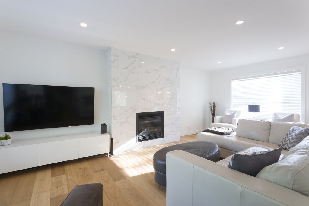 Custom-built family room with marble fireplace feature wall, sectional seating, and natural light