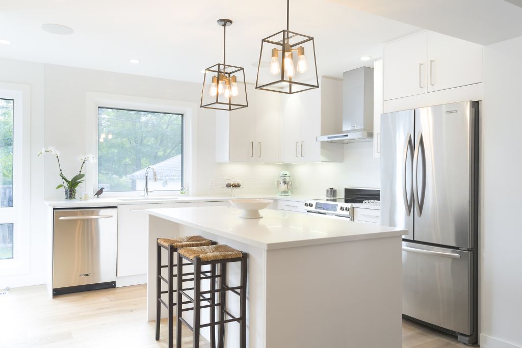 Modern kitchen design featuring stainless steel appliances and statement pendant lighting