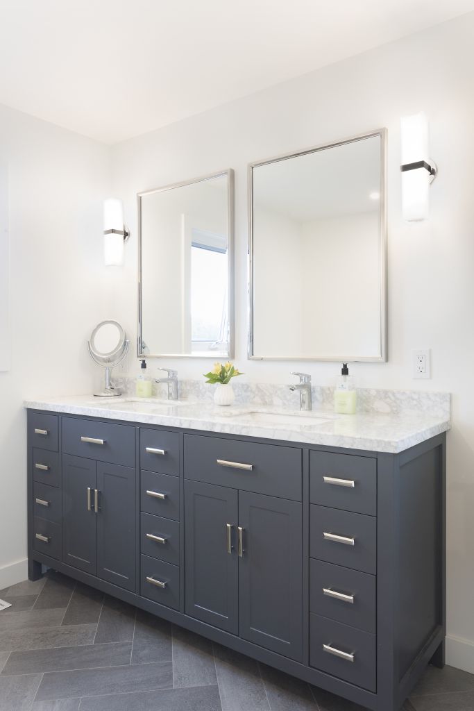 Stylish bathroom with double sink vanity, framed mirrors, and wall sconces
