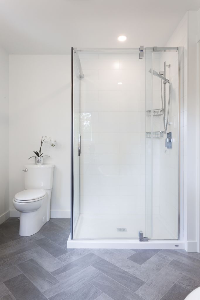 Luxury bathroom with sleek glass shower, rain showerhead, and gray tile floor