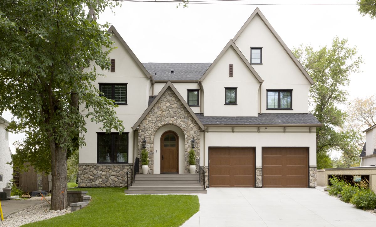 Custom home build with timeless materials: natural stone, wood accents, and architectural symmetry.