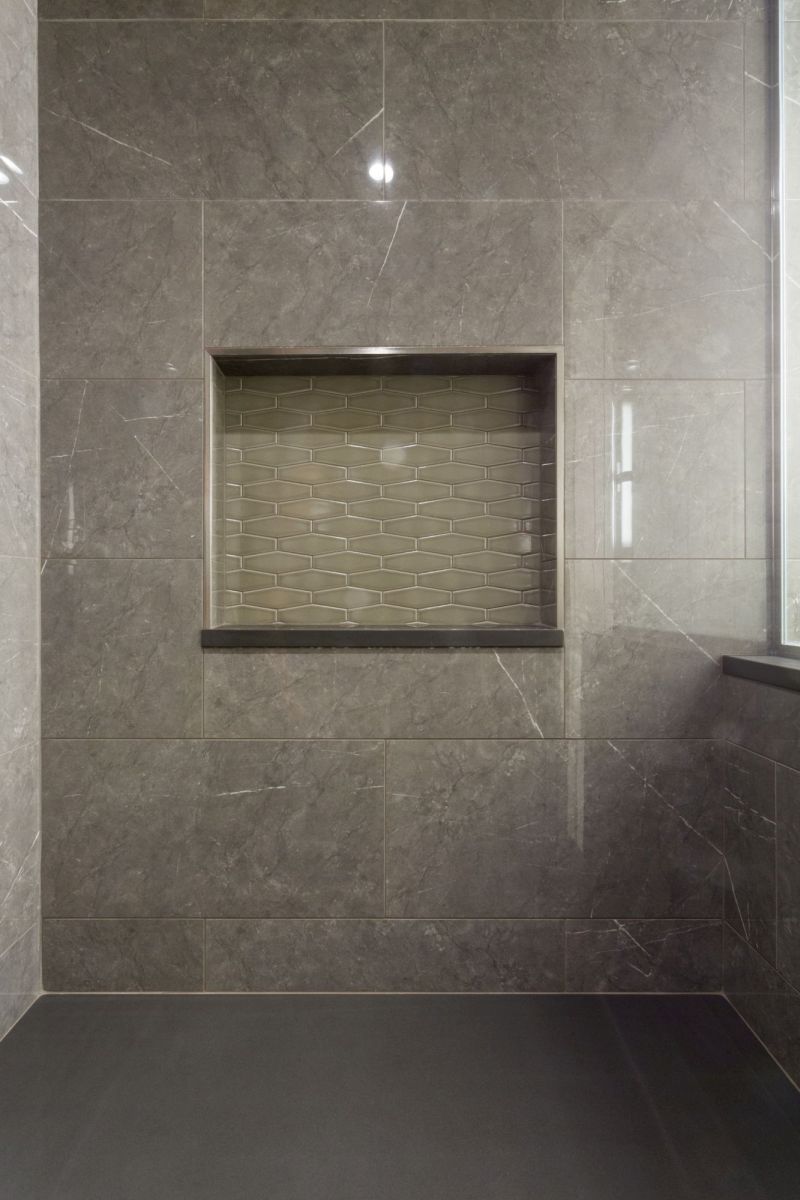 Inset shower shelf with decorative tile detail providing storage and visual interest