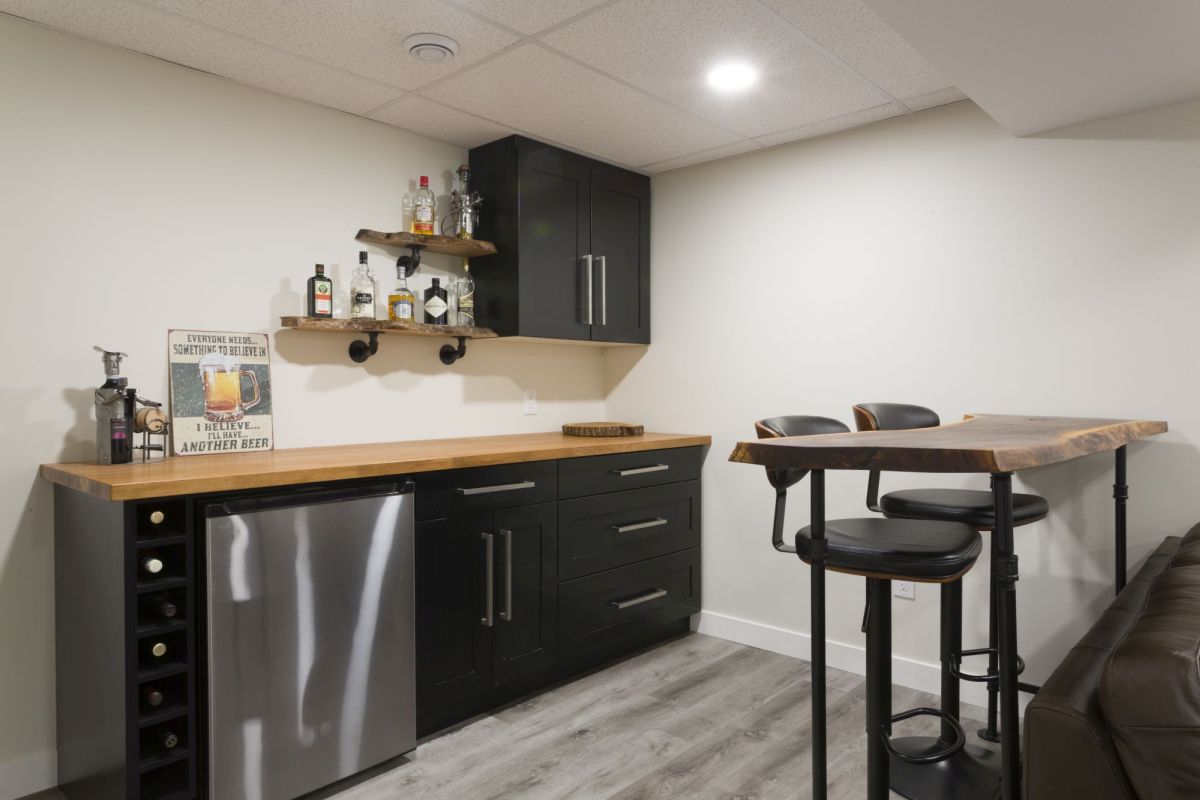 Contemporary bar nook with sleek black cabinetry, wood accents, and a cozy seating area