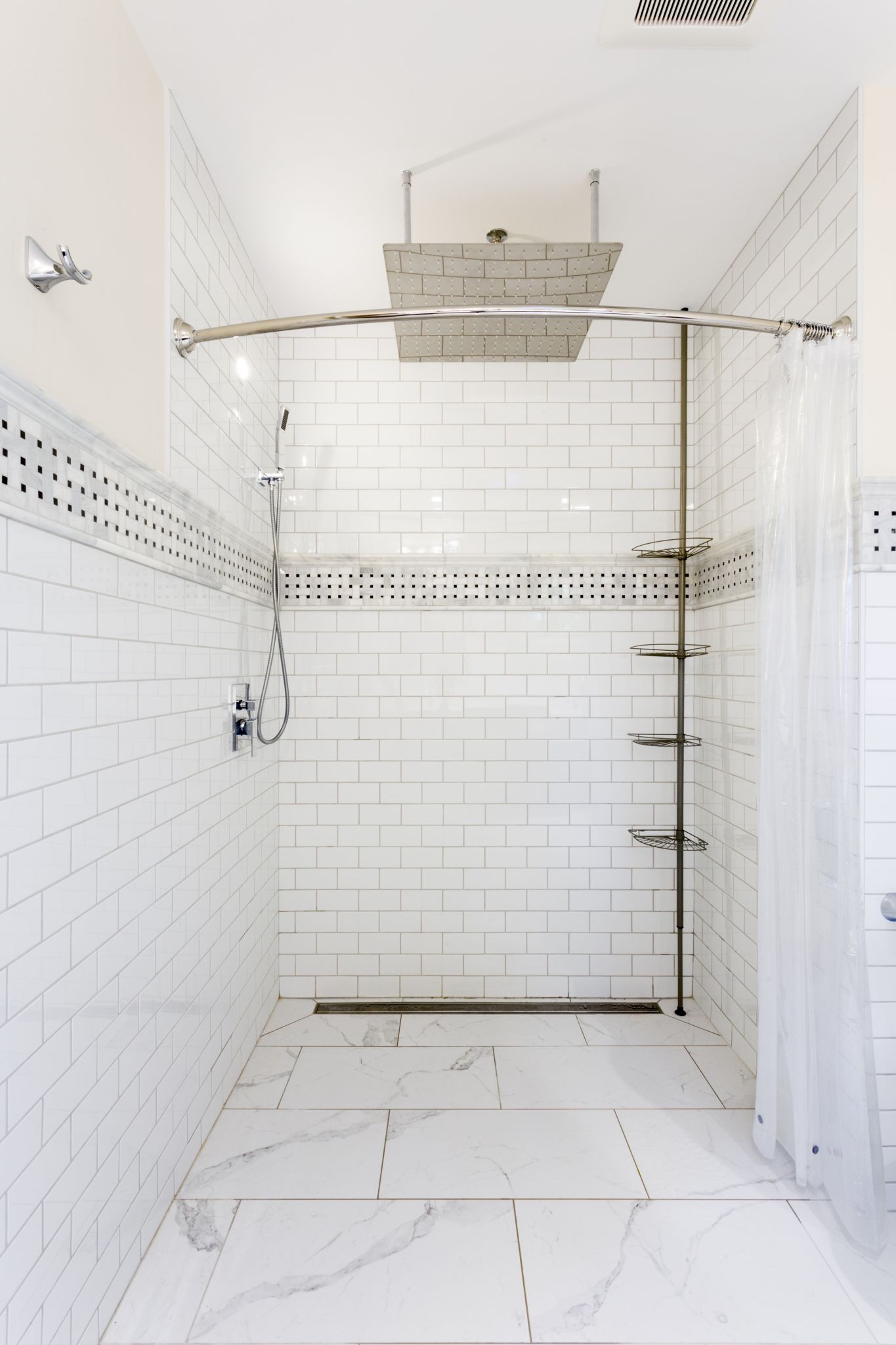 Timeless walk-in shower, classic subway tile, marble elegance, oversized rainfall head, patterned mosaic trim