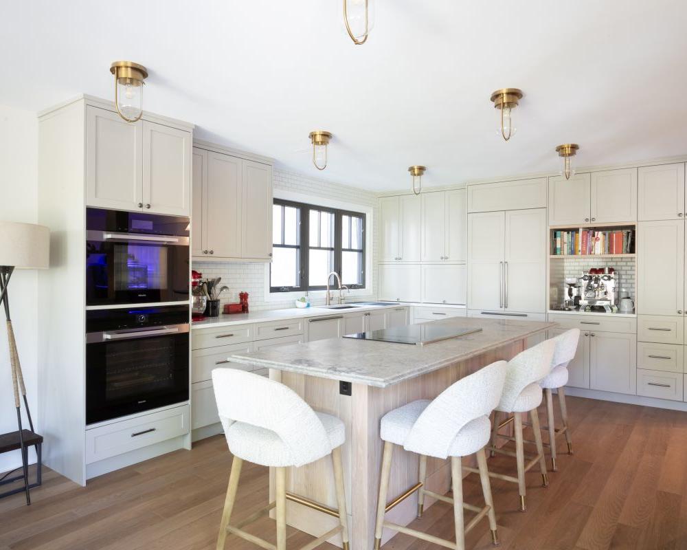 Custom luxury kitchen with high end countertops, gold accessories, and paneled refrigerator.