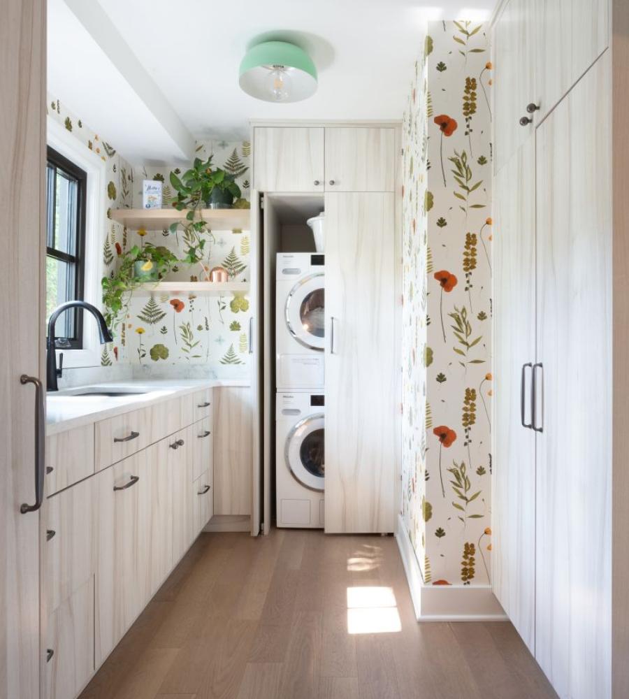 Laundry room with built in cabinets and accent wallpaper